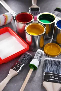 Paint cans and paintbrushes of different size  for home decorating purposes. Stock Photos