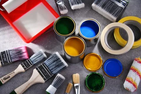Paint cans and paintbrushes of different size  for home decorating purposes. Stock Photos