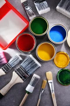 Paint cans and paintbrushes of different size  for home decorating purposes. Stock Photos