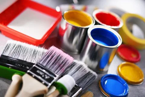 Paint cans and paintbrushes of different size  for home decorating purposes. Stock Photos