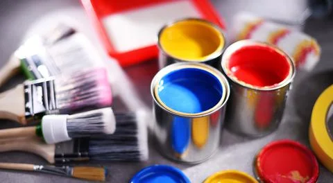 Paint cans and paintbrushes of different size  for home decorating purposes. Stock Photos