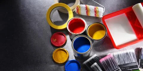 Paint cans and paintbrushes of different size  for home decorating purposes. Stock Photos
