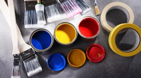 Paint cans and paintbrushes of different size  for home decorating purposes. Stock Photos