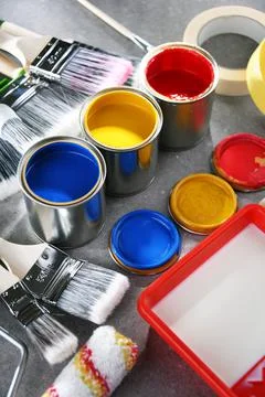 Paint cans and paintbrushes of different size  for home decorating purposes. Stock Photos