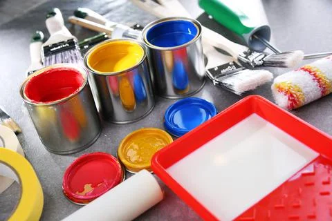 Paint cans and paintbrushes of different size  for home decorating purposes. Stock Photos
