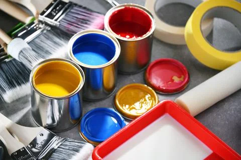 Paint cans and paintbrushes of different size  for home decorating purposes. Stock Photos
