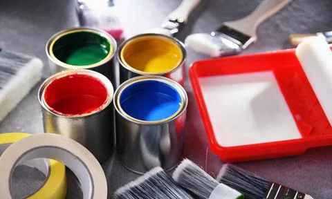 Paint cans and paintbrushes of different size  for home decorating purposes. Stock Photos