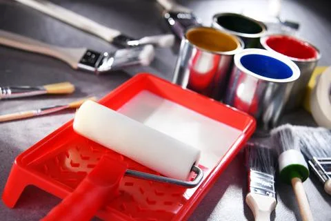 Paint cans and paintbrushes of different size  for home decorating purposes. Stock Photos