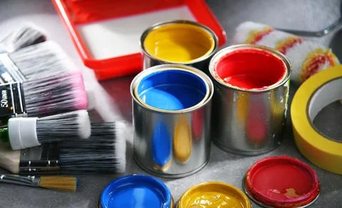 Paint cans and paintbrushes of different size  for home decorating purposes. Stock Photos