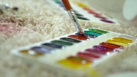 Paint drawing on a carpet close-up/art, brush, carpet, green, blue, red Stock Footage 71001846