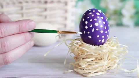 Paint the Easter egg with a brush, put white dots Stock Footage 233180349