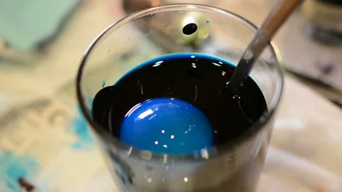 Paint Easter eggs in a glass in blue Stock Footage 88155163