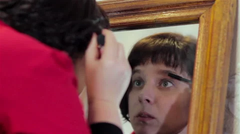 Paint eyelashes in the mirror Stock Footage 58712149