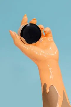 The paint flows down the arm. Blue background. Stock Photos