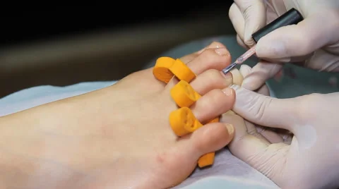 To paint her toenails Stock Footage 64570106