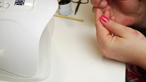 Paint the nails on the hand and dries in a UV lamp.Manicure at home. 스톡 동영상 130428094