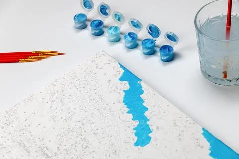 A paint-by-numbers project in progress, featuring blue painted areas on the c Foto stock