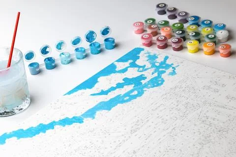 A paint-by-numbers project in progress, featuring blue painted areas on the c Stock Photos