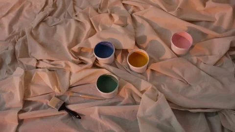 Paint pots and brushes on a draped fabric background Stock-Footage 334573048
