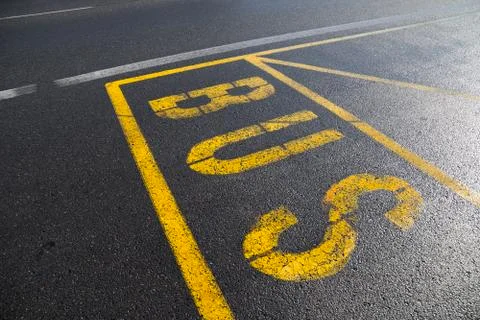 Paint on the road as marking of bust stop and station. Yellow lines and text Stock Photos