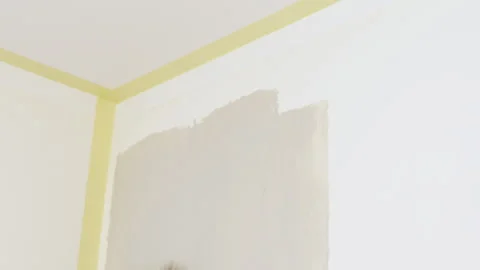 Paint roller applying beige color on wall corner Video stock 327303646
