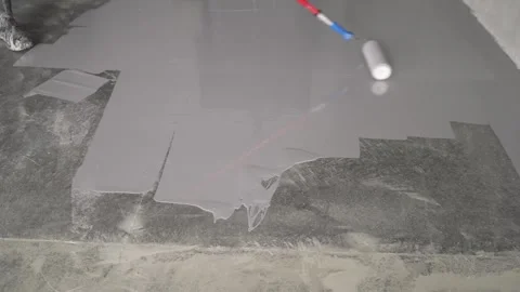 Paint roller applying gray floor coating on concrete surface. Closeup of paint Stock Footage 337038715