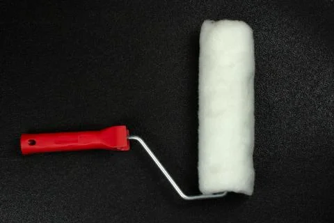 Paint roller on a black background, top view Stock Photos