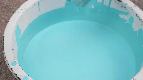 Paint roller in a blue bucket waiting for the paint to drip. Stock Footage 148673310