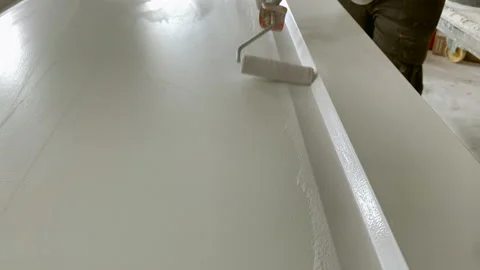 Paint roller closeup. Painter at work paints the wooden door with white paint Stock-Footage 156659968