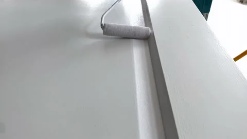 Paint roller closeup. Painter at work paints the wooden door with white paint Stock Footage 156660671