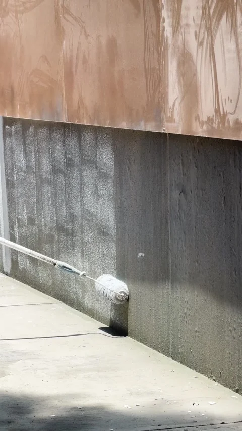 Paint Roller Coating Exterior Concrete Wall Beside Sidewalk in Vertical Outdoor Stock Footage 344458234