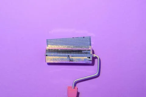 Paint roller covered with mirror disco tiles creates sparkling illusion on Foto stock