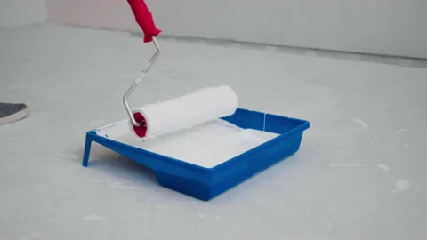 Paint roller is dipped in white paint in a tray. Stock Footage 148233892