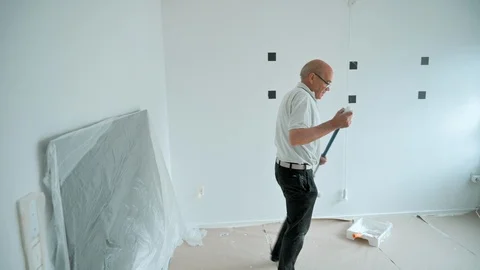 Paint roller gets used to make home improvement in a living room Stock Footage 107270082