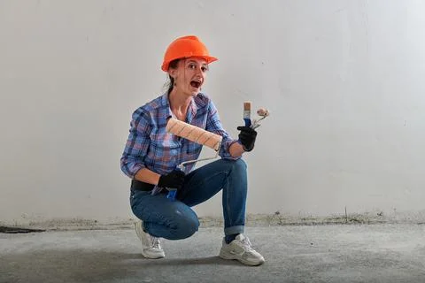 Paint roller in the hands of a funny foreman with brushes Stock Photos