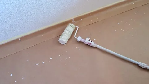 Paint roller lies on a floor during home renovation Vídeos de archivo 341362828