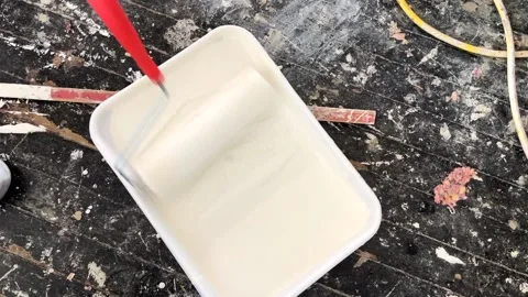 The paint roller moves in a container of white paint. Stock Footage 206167684