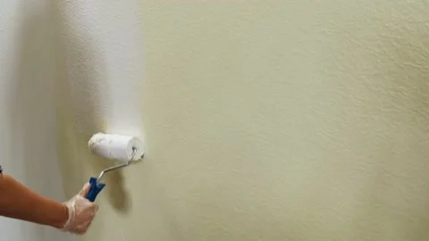 Paint Roller Moves on the Wall and painting yellow wall with white paint. Stock Footage 165223104