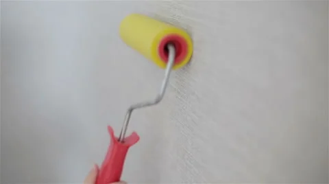 A paint roller moving up and down on the wallpaper Stock Footage 62333210