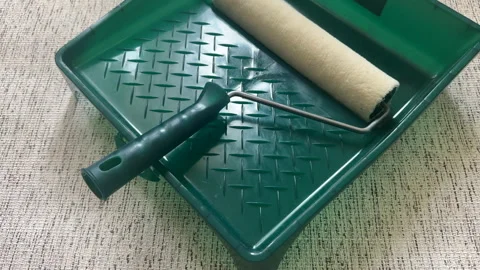 Paint roller with paint in container room. Painting the walls Stock Footage 270309099