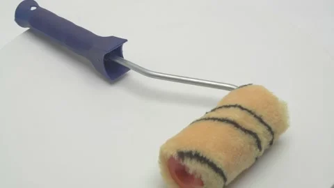 A paint roller rotates on a white background. Video stock 266998298