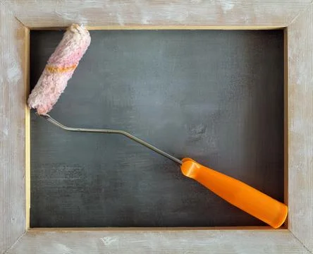 Paint Roller in Rustic Frame on Dark Textured Background Photos