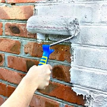 Paint roller through a brick wall Stock-Fotos