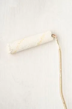 Paint roller for whitewashing on surface with copy space Stock Photos