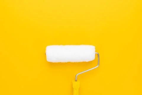 Paint roller on yellow background Stock Photos