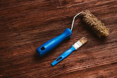 Paint rollers and brush on the dark wooden background Stock Photos