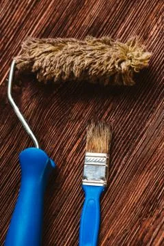 Paint rollers and brush on the dark wooden background Stock Photos