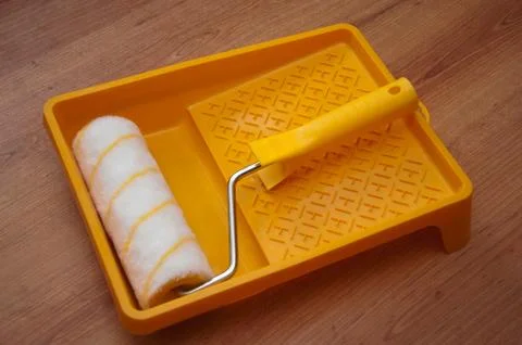 Paint rollers and brush on yellow tray Stock Photos