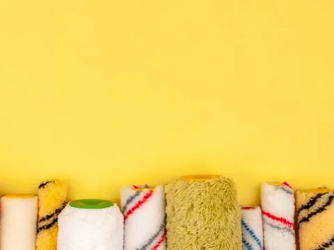 Paint rollers on a yellow background. Stock Photos