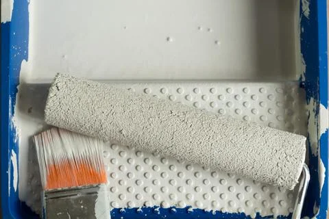Paint set: roller, brush in tray bath and spatula on the concrete floor, close Stock Photos